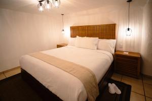 een slaapkamer met een groot bed en 2 verlichting bij BOTANIQ HOTEL BOUTIQUE in Valle de Bravo