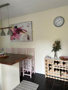 une cuisine avec une table et une horloge murale dans l'établissement The Lodge-Cozy and serene home, à Cavan