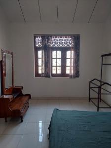 1 dormitorio con cama, espejo y ventana en Fernando Residencies, en Wennappuwa