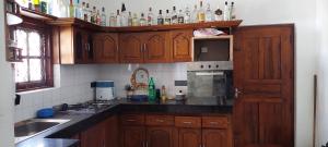 una cocina con armarios de madera y botellas en la pared en Fernando Residencies, en Wennappuwa