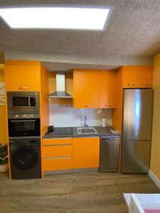 a kitchen with orange cabinets and a stainless steel refrigerator at Casa Dakar in Valdemaluque