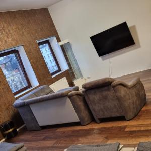 uma sala de estar com 2 sofás e uma televisão de ecrã plano em Kiezloft em Hamburgo