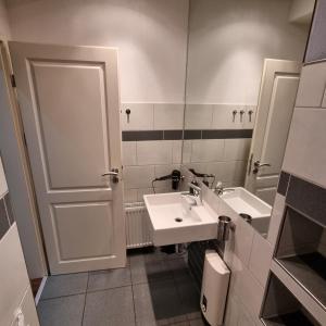 een badkamer met een wastafel en een spiegel bij Kiezloft in Hamburg