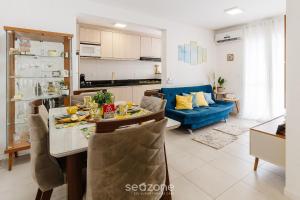 a kitchen and living room with a table and a blue couch at EAO - Apartamentos completos em Joinville/SC in Joinville