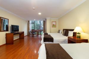 a hotel room with two beds and a flat screen tv at Hotel NASS Pinar del Lago in Cuenca