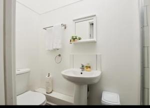 Baño blanco con aseo y lavamanos en Spacious 4 bedroom house in Wallasey for 7 people with parking BridgeCity, en Wallasey