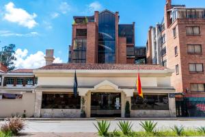 a building with two flags in front of it at Hotel NASS Pinar del Lago in Cuenca