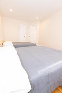 a white bed in a bedroom with white walls at Astonishing 3-Bed Apt Close to NYC in Jersey City
