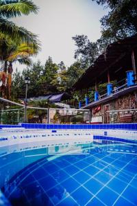 een groot zwembad met een blauwe tegelvloer bij FINCA HOTEL SANTO TOMAS REAL in Rionegro