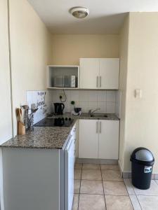 a kitchen with white cabinets and a counter top at Oceanic Apartment - Ocean views - Self-Catering in Durban