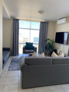 a living room with a couch and a flat screen tv at Oceanic Apartment - Ocean views - Self-Catering in Durban