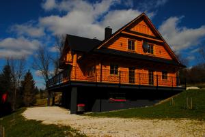 una gran casa de madera con techo de gambrel en Chatka Pod Laskiem - Domki w górach en Sablówka