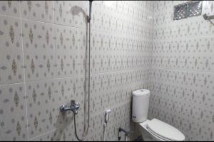 a bathroom with a shower and a toilet at SUPER OYO Gandaria Guest House Near Masjid Raya Sumatera Barat in Padang
