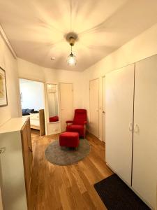 uma sala de estar com uma cadeira vermelha e um quarto em Laivurinkatu 35 em Helsinque