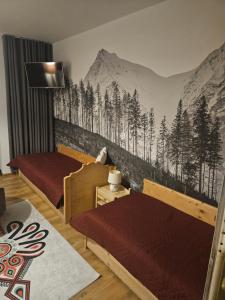 een slaapkamer met een muurschildering van bomen en bergen bij HALNY in Białka Tatrzanska