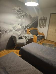 een slaapkamer met 2 bedden en een muurschildering van de bergen bij HALNY in Białka Tatrzanska