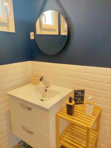 ein Badezimmer mit einem weißen Waschbecken und einem Spiegel in der Unterkunft L'étape Nuitonne - Gîte avec jardin pour 6 personnes in Nuits-Saint-Georges