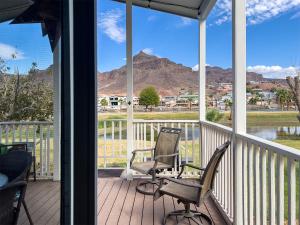 - deux chaises sur une terrasse couverte offrant une vue sur la montagne dans l'établissement Siren's Adventure Riverfront Cottage!, 