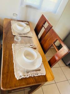 uma mesa de madeira com pratos e copos em Naty’s Apartamento em La Cruz