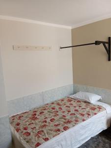 - une chambre avec un lit et une couverture de fleurs dans l'établissement Goya'sHostel, à Camaná