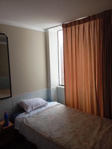 een kleine slaapkamer met een bed en een raam bij Goya'sHostel in Camaná