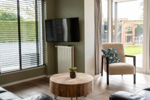 a living room with a coffee table and a chair at Holidayhome BB 17 a. in Aagtekerke