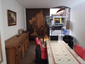 a dining room with a table and a painting on the wall at Les Voisins De Mr Sax in Dinant