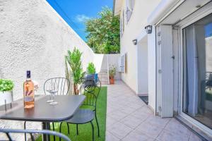 una mesa con una botella de vino en el patio en Bas de villa près du stade Vélodrome en Marsella