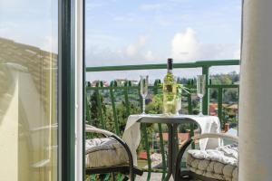 a table with a wine bottle and glasses on a balcony at Bella Istria Apartment in Korte