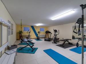 einen Fitnessraum mit mehreren Laufbändern und Heimtrainern in der Unterkunft Ferienwohnanlage-Oberaudorf F 2mit Hallenbad und Sauna in Oberaudorf