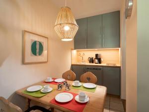 a small kitchen with a wooden table with plates on it at Bergschlössl - Maissonettwohnung 14 in Oberaudorf