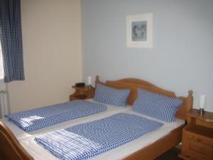 a bed with two blue and white pillows on it at Bergschlössl Whg 3 in Oberaudorf