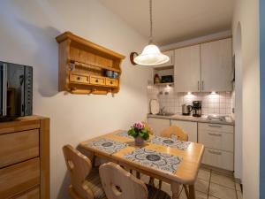 eine Küche mit einem Esstisch mit Stühlen und einem Tisch in der Unterkunft Bergschlössl - Massionettwohnung 12 in Oberaudorf