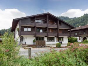 a large wooden house with mountains in the background at Moderne Bergstube mit 2 Schlafzimmer und großen Balkon in Oberaudorf