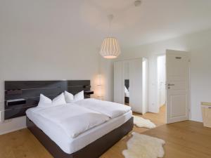 a bedroom with a large white bed with a black headboard at Moderne Bergstube mit 2 Schlafzimmer und großen Balkon in Oberaudorf