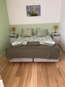 a bedroom with a large bed with two night stands at Tulpenzicht in Zilk