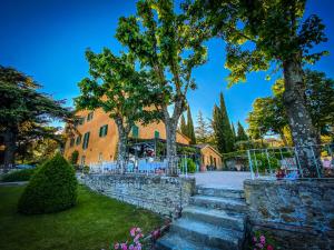 un edificio con árboles y escaleras en un patio en I Capricci Di Merion - Resort & Spa, en Tuoro sul Trasimeno