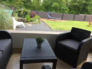 eine Terrasse mit 2 Stühlen, einem Tisch und einer Bank in der Unterkunft Fewo-Eifelfroh in Gunderath