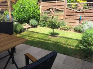 eine Terrasse mit einem Tisch und Stühlen sowie einem Garten in der Unterkunft Fewo-Eifelfroh in Gunderath + 9 Fotos
