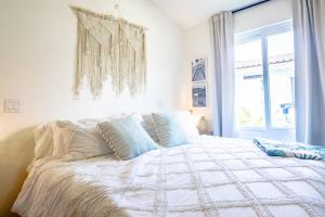 een wit bed in een slaapkamer met een raam bij Blue Venao Ocean Oasis 3BR / Villa 17 in Playa Venao