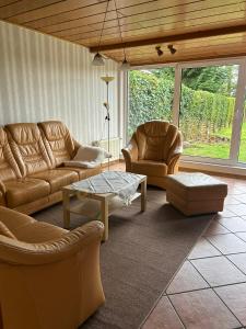 uma sala de estar com dois sofás e uma mesa de centro em Ferienhaus Nannen em Rechtsupweg