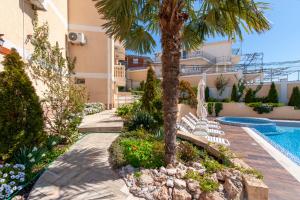 a resort with a palm tree and a swimming pool at Villa Orpheus in Bar