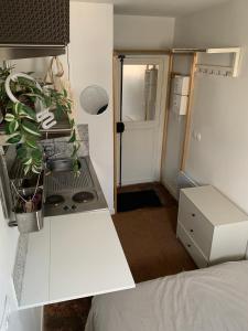 una pequeña cocina blanca con fogones y 1 cama en Parisian Charm - Heart of Saint-Germain-des-Prés Elegance en París