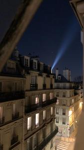 un edificio con una luz encima por la noche en Parisian Charm - Heart of Saint-Germain-des-Prés Elegance en París
