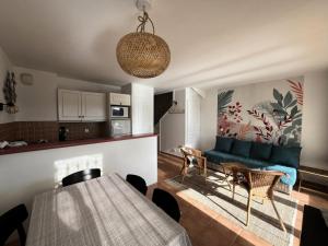 un salon avec un canapé bleu et une table dans l'établissement Village Pont Royal en Provence - maeva Home - Maison climatisée 4 pièces 6 personnes - Sélection MAE-7054, à Mallemort