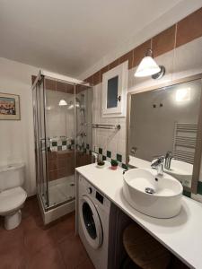 une salle de bain avec un lavabo et une machine à laver dans l'établissement Village Pont Royal en Provence - maeva Home - Maison climatisée 4 pièces 6 personnes - Sélection MAE-7054, à Mallemort