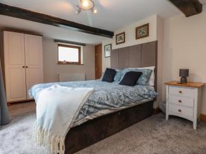 a bedroom with a large bed with a wooden headboard at Lake View Cottage in Longford