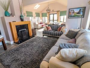 een woonkamer met een bank en een open haard bij 2 Ocean View in Doonbeg