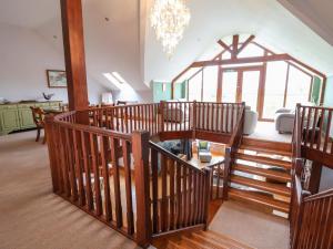 a large room with wooden stairs and a chandelier at Lake View Cottage in Longford