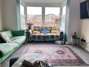 a living room with a couch and a large window at Cozymodrenroom in Brighton & Hove